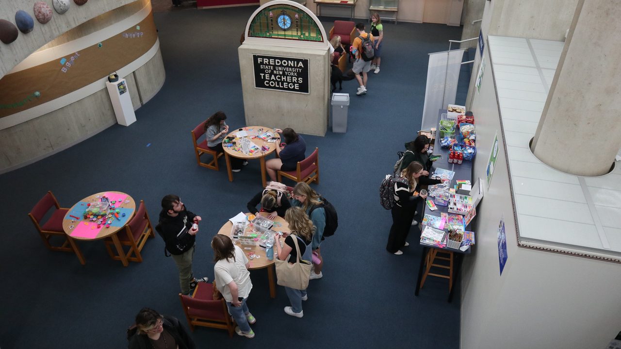 Students at craft and coloring tables across the library's OSCAR Hub