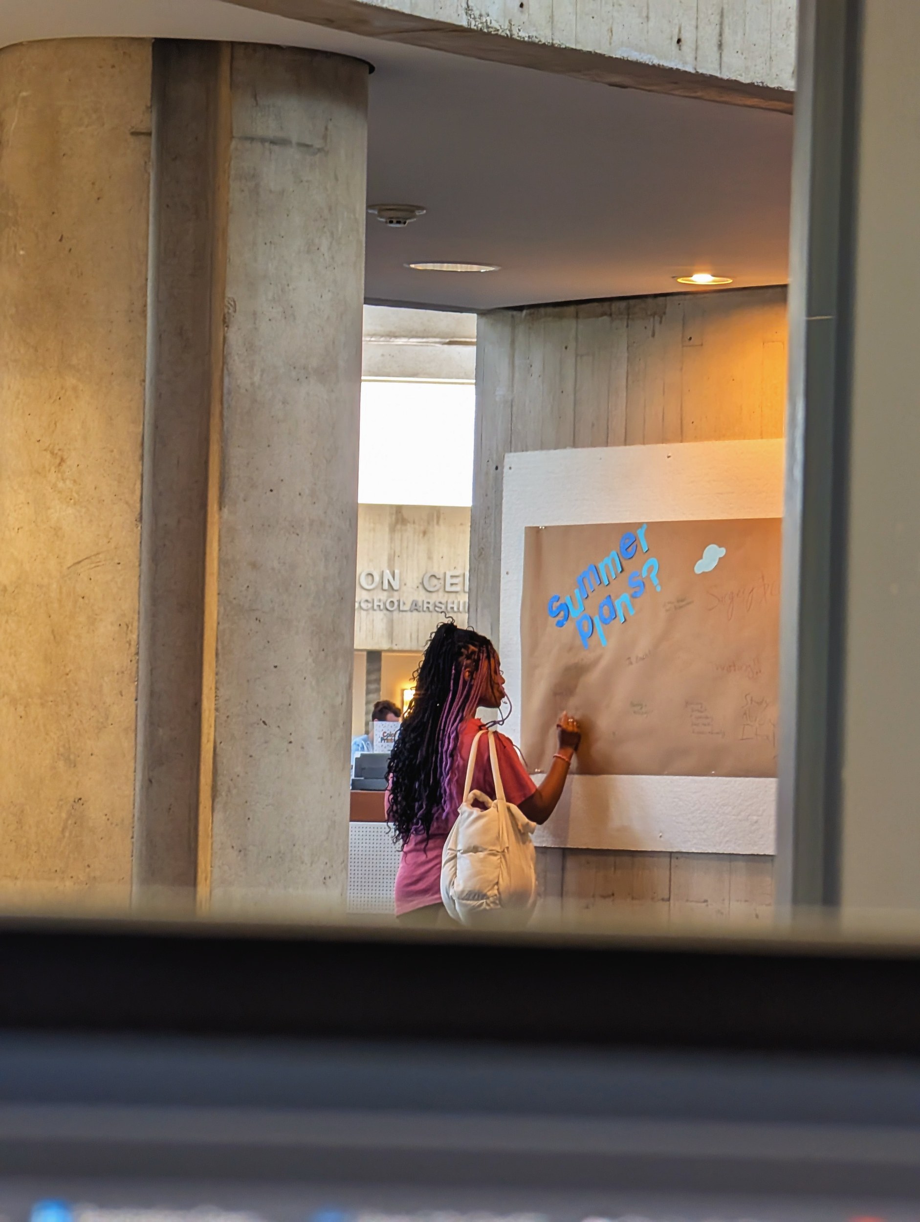 A student writing on the prompt wall
